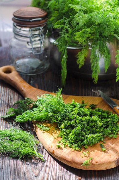 Jeune aneth vert fraîchement coupé haché sur une planche de cuisine