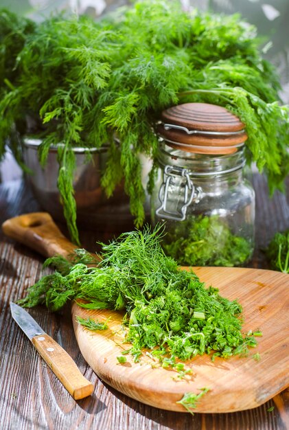 Jeune aneth vert fraîchement coupé haché sur une planche de cuisine