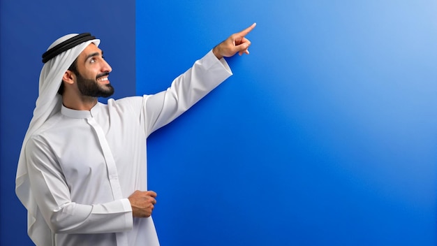 Photo un jeune arabe s'appuyant contre une surface pointant vers l'espace de copie avec une expression pensive ag