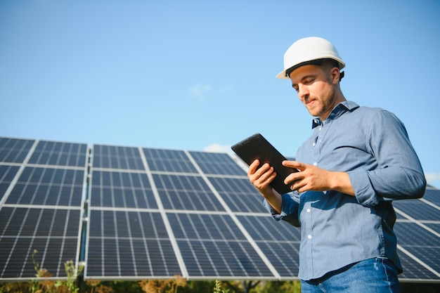 Jeune architecte debout près de panneaux solaires