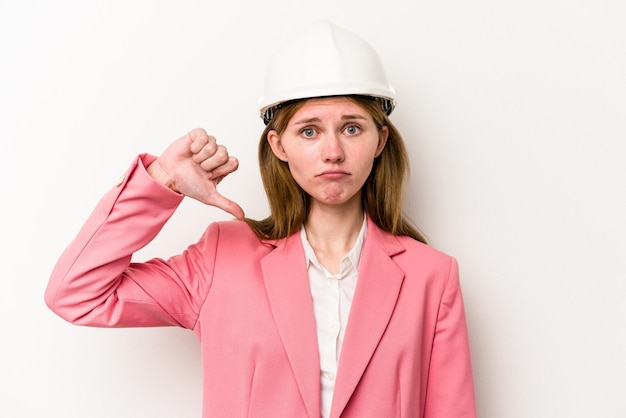 Jeune architecte femme anglaise avec casque isolé sur fond blanc montrant un geste d'aversion pouce vers le bas Concept de désaccord