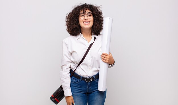 Jeune architecte à la femme heureuse et agréablement surprise, excitée par une expression fascinée et choquée