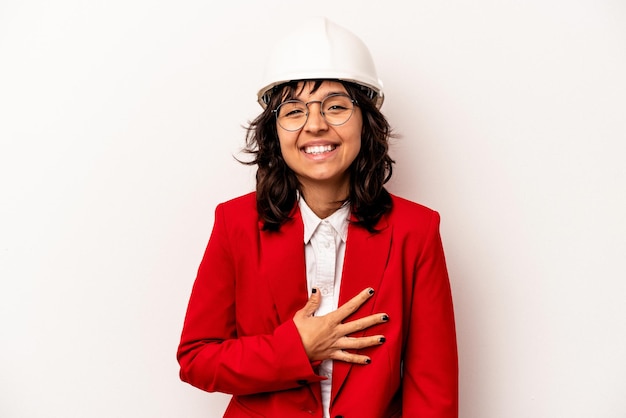Jeune architecte femme hispanique avec casque isolé sur fond blanc rire et s'amuser