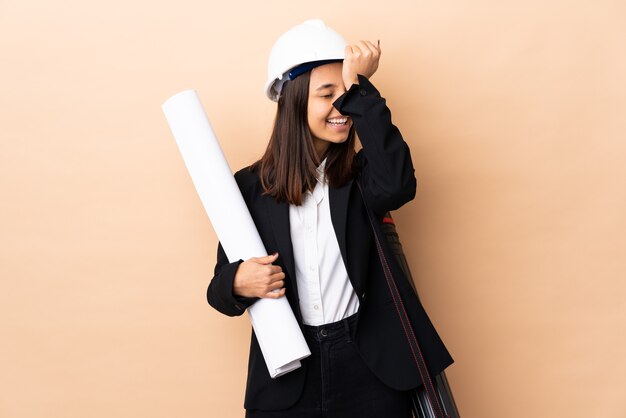 Jeune architecte femme tenant des plans sur un mur isolé a réalisé quelque chose et l'intention de la solution