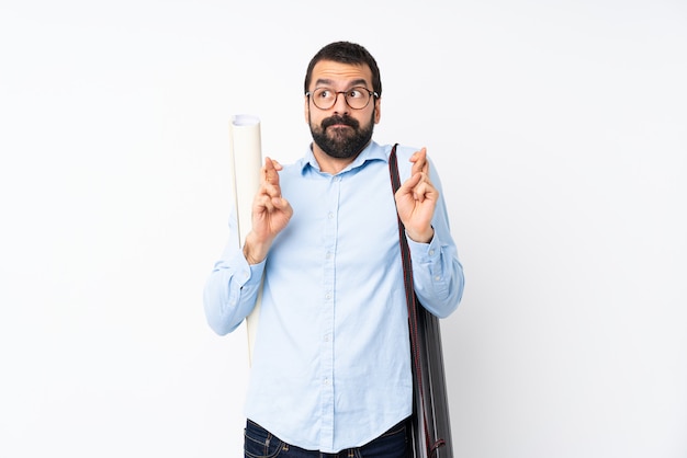 Jeune architecte homme à la barbe sur blanc isolé avec les doigts qui se croisent et souhaitant le meilleur