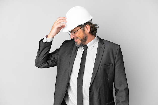 Jeune architecte homme avec casque sur fond isolé en riant