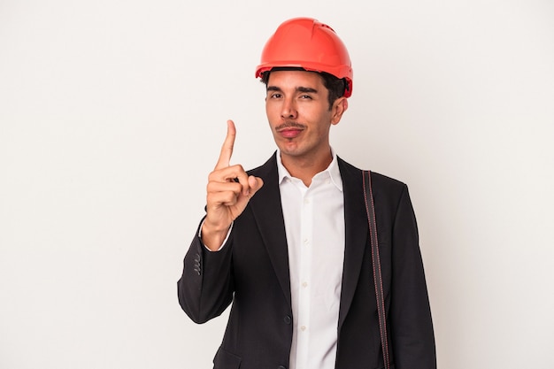 Jeune architecte homme de race mixte isolé sur fond blanc montrant le numéro un avec le doigt.