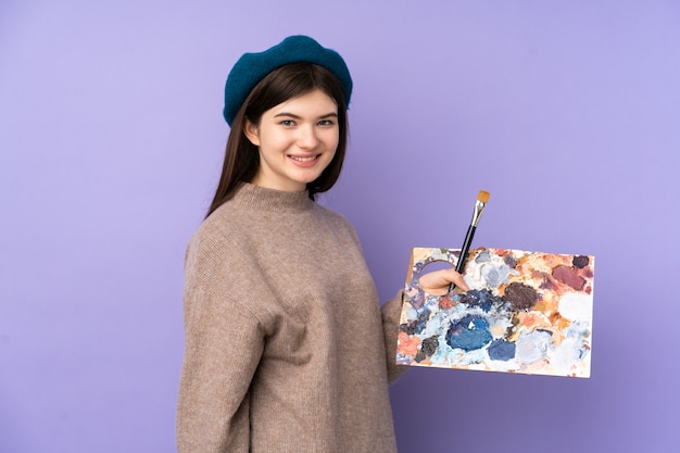 Jeune artiste femme tenant une palette souriant beaucoup