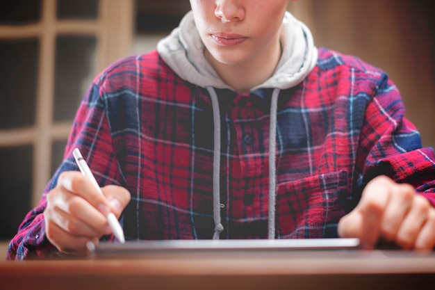 Jeune artiste masculin dessine sur une tablette numérique en studio