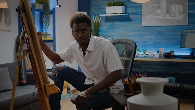 Jeune artiste noir dessinant et s'inspirant de la conception de vase sur table. Personne afro-américaine assise dans un studio d'atelier créant un chef-d'œuvre d'art comme passe-temps professionnel