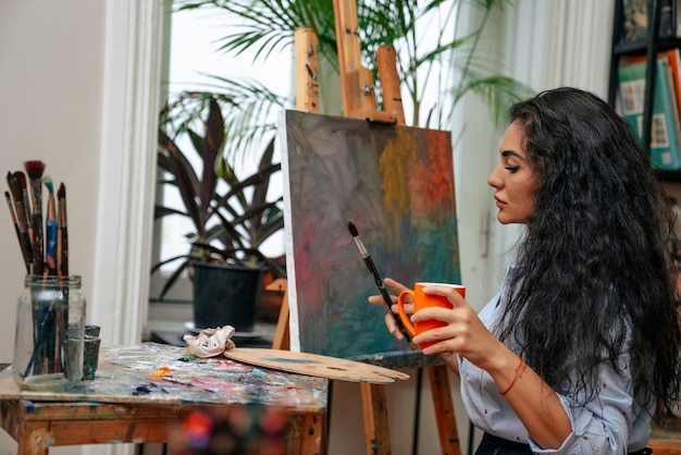 Jeune artiste travaillant sur une peinture à l'atelier