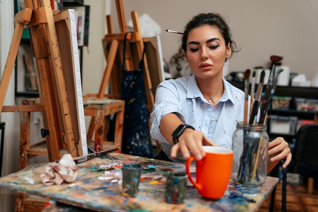 Jeune artiste travaillant sur une peinture à l'atelier