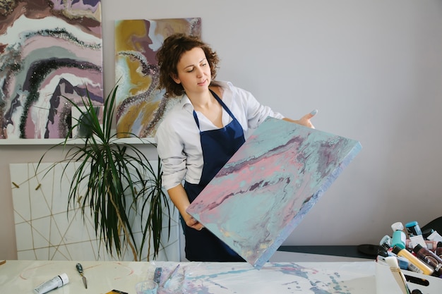 Jeune artiste travaillant avec des peintures acryliques sur toile