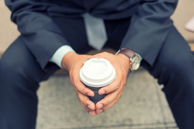 Jeune asiatique bel homme d&#39;affaires, boire du café chaud dans la ville moderne. Briser et relaxer busin