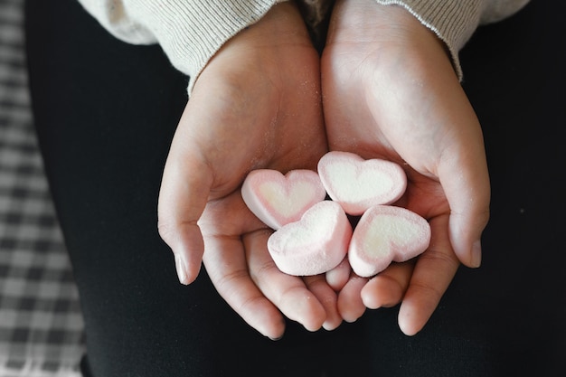 Jeune asiatique avec des bonbons coeur dans les mains.