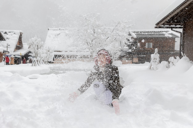 Jeune asiatique jouant de la neige dans le village de shirakawa à Osaka, Japon