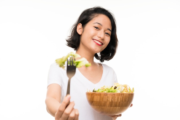 Jeune asiatique sur mur isolé avec salade