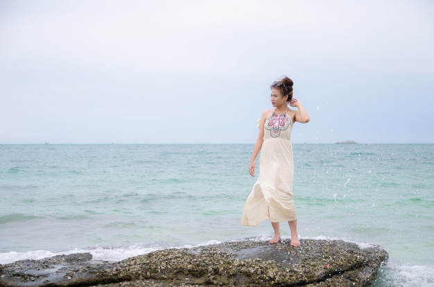 Jeune asiatique portrait debout sur pierre mer