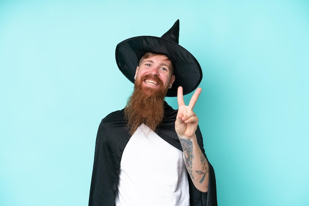 Jeune assistant à halloween isolé sur fond bleu souriant et montrant le signe de la victoire