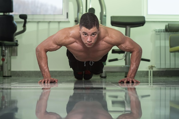 Jeune athlète adulte faisant des pompes dans le cadre d'une formation de musculation