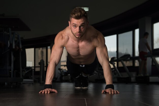 Jeune athlète adulte faisant des pompes dans le cadre d'une formation de musculation