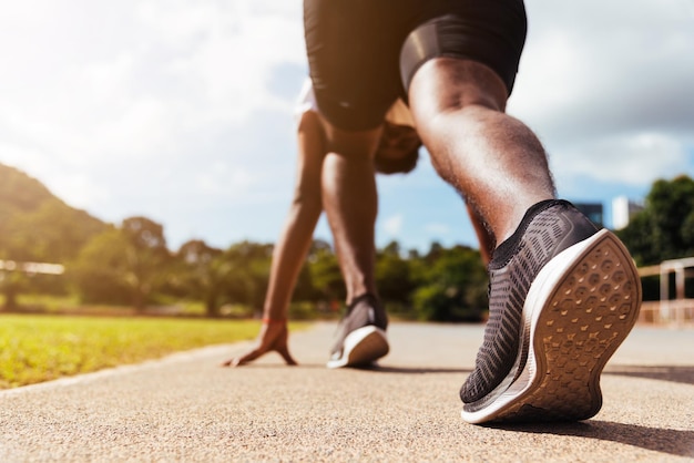 Jeune athlète asiatique coureur de sport homme noir actif prêt à commencer à courir s'entraîner à l'extérieur sur le tapis roulant pour un pas en avant, un entraînement sain, un gros plan sur la chaussure des pieds