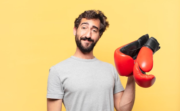 Jeune athlète barbu fou expression heureuse et tenant des gants de boxe