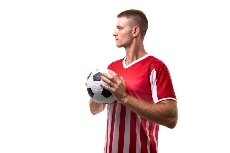 Photo un jeune athlète caucasien confiant tenant un ballon de football en regardant loin sur un fond blanc