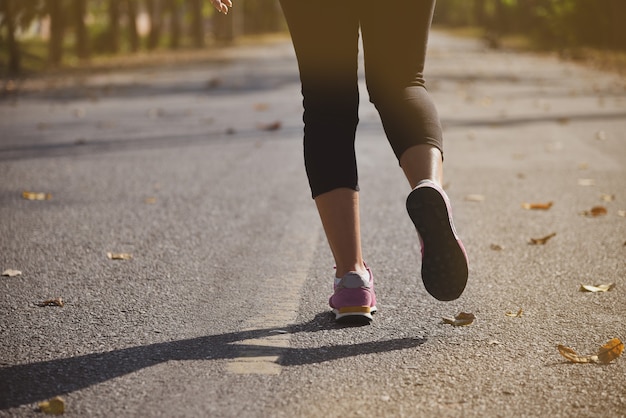 Jeune athlète de coureur de femme de forme physique courant à la route