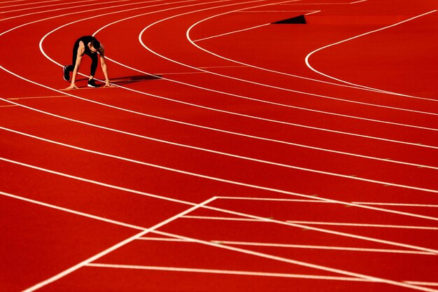 Photo un jeune athlète court autour du stade vêtu d'un vêtement de sport noir se prépare pour la compétition