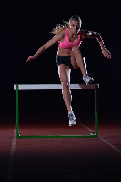 Une jeune athlète déterminée sautant par-dessus des obstacles