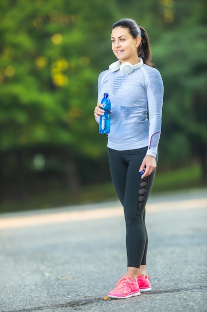 Une jeune athlète féminine boit de l'eau après l'entraînement.