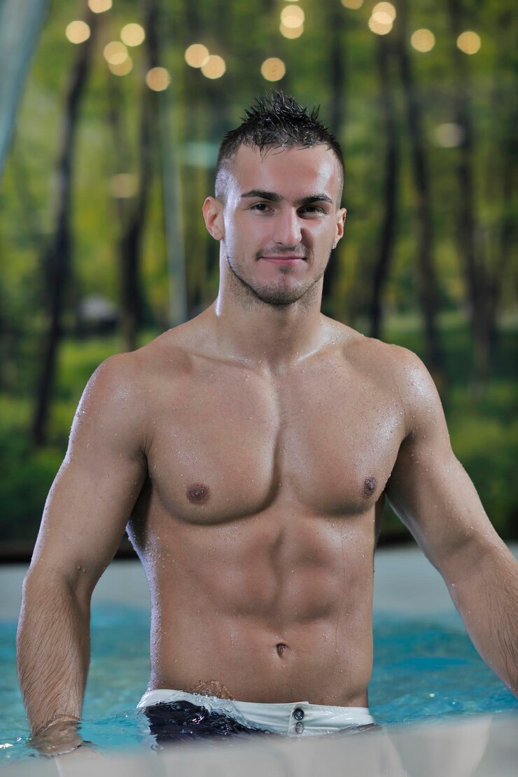 Jeune athlète modèle Macho Man en bonne santé à la piscine intérieure de l'hôtel