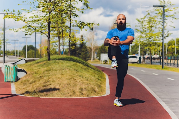 Jeune athlète qui court vite à l'extérieur. Porter un vêtement de sport, faire un pas large, démontrer un mode de vie sain, plan large.