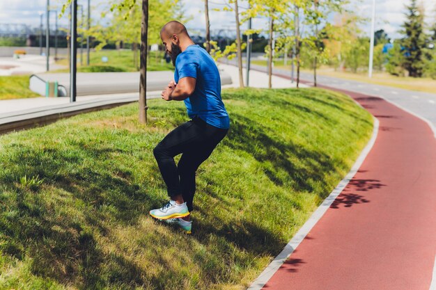 Jeune athlète qui court vite à l'extérieur. Porter un vêtement de sport, faire un pas large, démontrer un mode de vie sain, plan large.