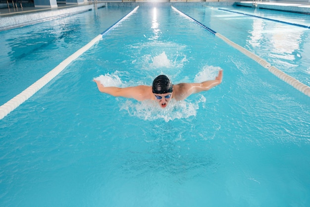 Un jeune athlète s'entraîne et se prépare pour des compétitions de natation dans la piscine. Mode de vie sain.