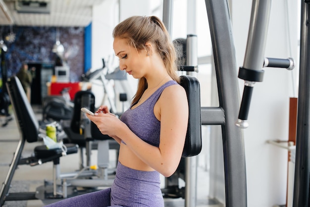 Une Jeune Athlète Utilise Son Téléphone Dans La Salle De Sport Et Prend Un Selfie.