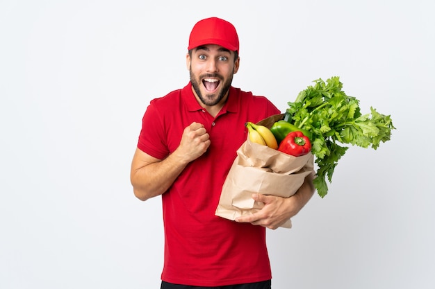 Jeune, barbe, tenue, sac, plein, legumes, isolé, blanc, mur, célébrer, victoire