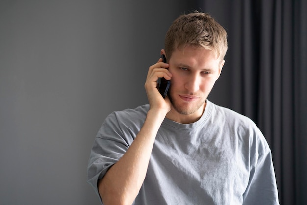 Un jeune barbu faisant un appel téléphonique