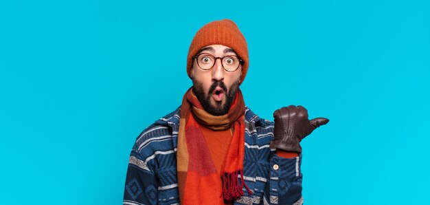 Jeune barbu fou. expression choquée ou surprise et portant des vêtements d'hiver