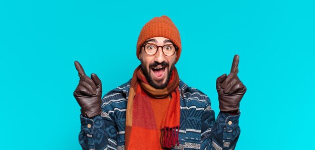 Photo jeune barbu fou. expression choquée ou surprise et portant des vêtements d'hiver