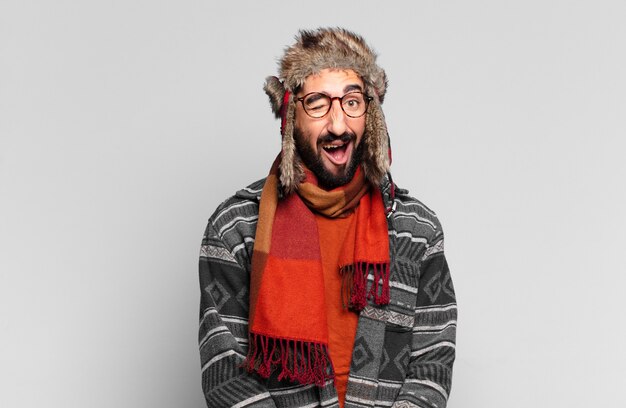 Jeune barbu fou. expression heureuse et surprise et portant des vêtements d'hiver