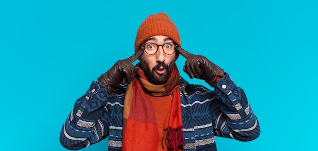 Jeune barbu fou. penser ou douter de l'expression et porter des vêtements d'hiver