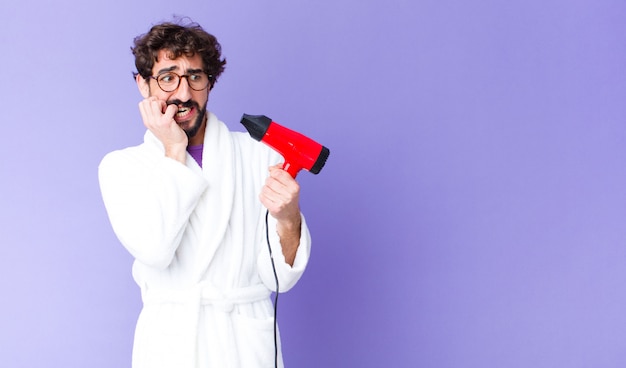 Jeune barbu fou portant un peignoir avec un coiffeur