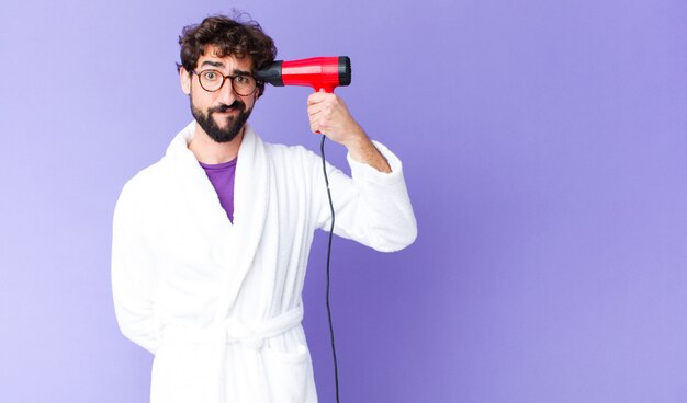 Jeune barbu fou portant un peignoir avec un coiffeur