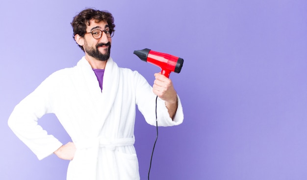 Jeune barbu fou portant un peignoir avec un coiffeur