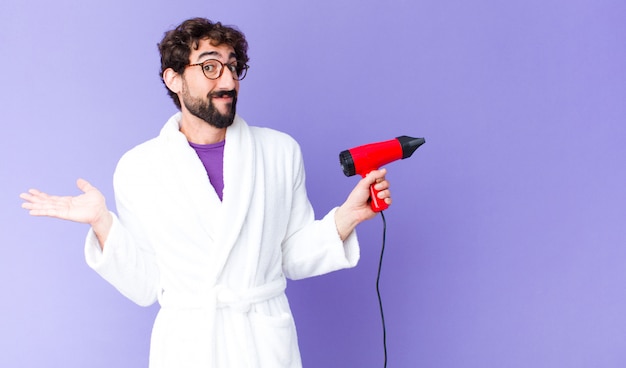 Jeune barbu fou portant un peignoir avec un coiffeur