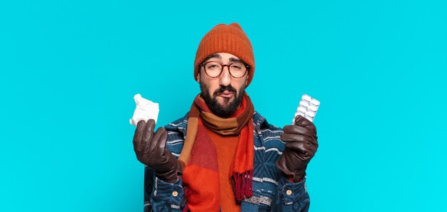 Jeune barbu fou et portant des vêtements d'hiver. notion de maladie