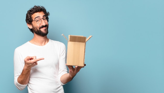 Jeune barbu fou recitant un emballage en carton