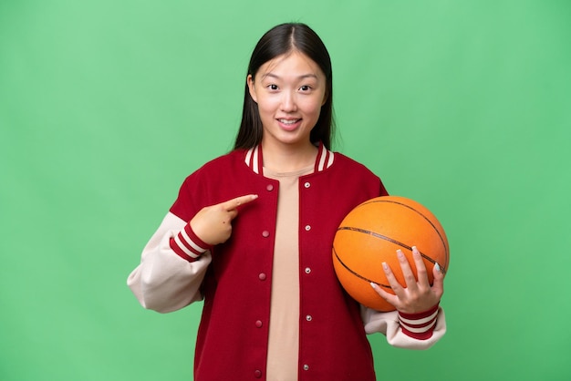 Jeune basketteur femme asiatique sur fond isolé avec une expression faciale surprise